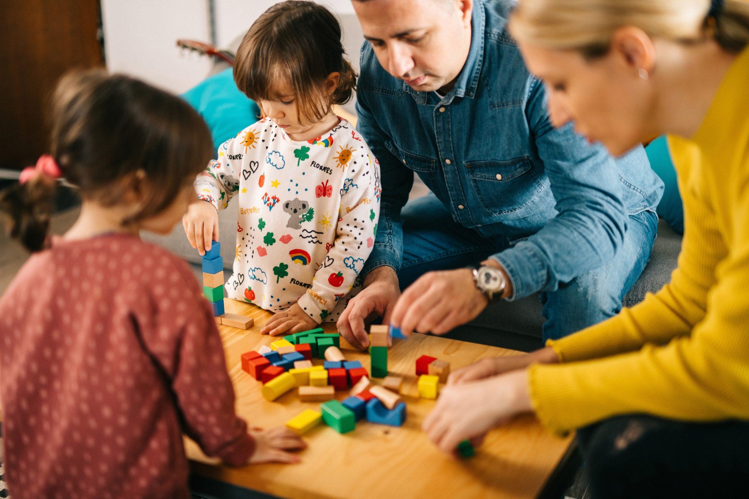 Photo of family is playing with wooden cubes at home